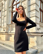Rochie neagra elegantă mini cu mâneci, ajustată pe corp.