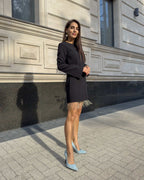 Rochie neagra scurtă cu franjuri din cristale și mâneci lungi, detalii decorative, purtată afară.