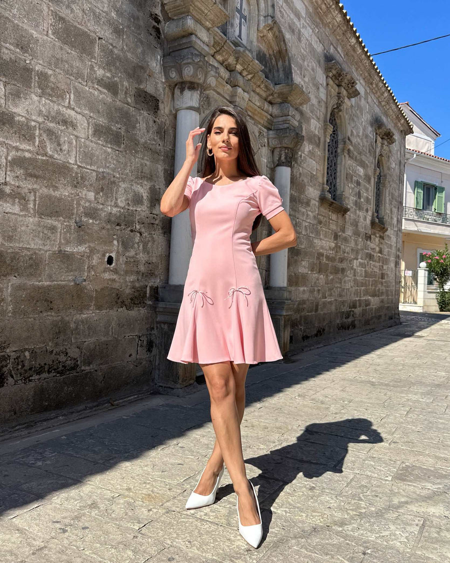 Rochie scurta roz cloș din stofă elastică, elegantă, cu mâneci scurte și fermoar la spate.