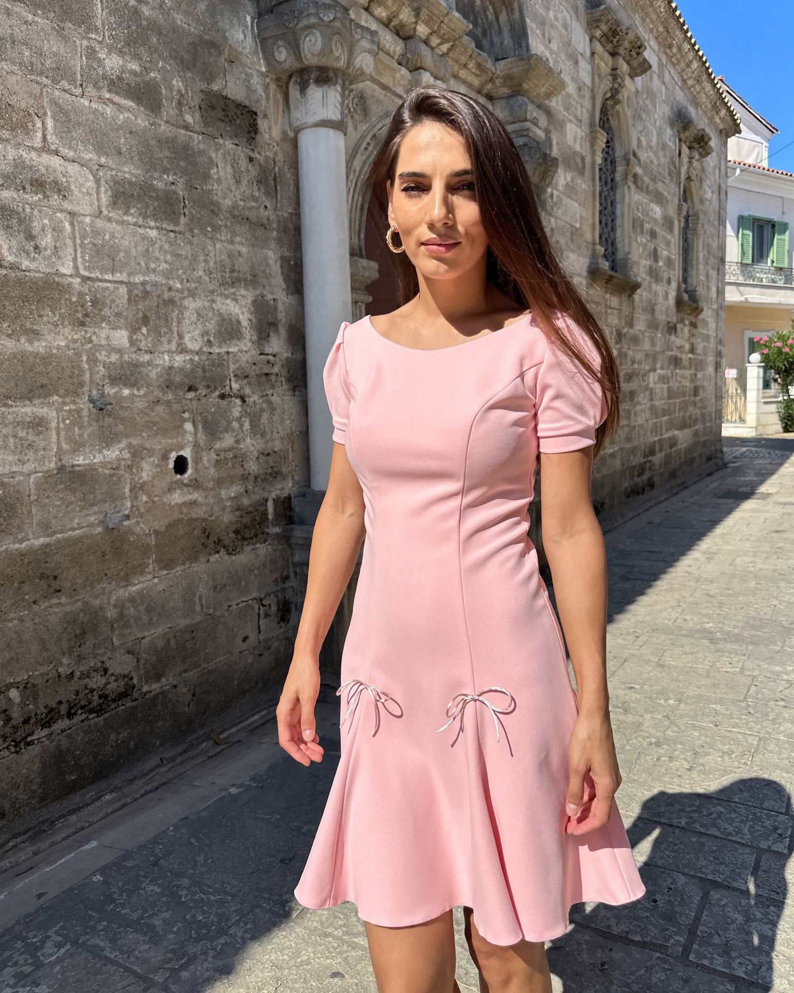 Rochie scurta roz cloș din stofă elastică, elegantă, cu mâneci scurte și fermoar la spate.