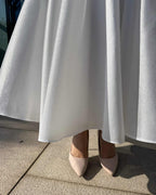 Rochie de mireasa midi albă, elegantă, cu buzunare și detalii moderne.