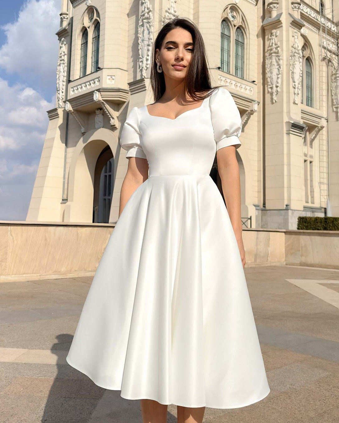 Rochie eleganta de ocazie albă cu croială A-line, design rafinat, fundal arhitectural.