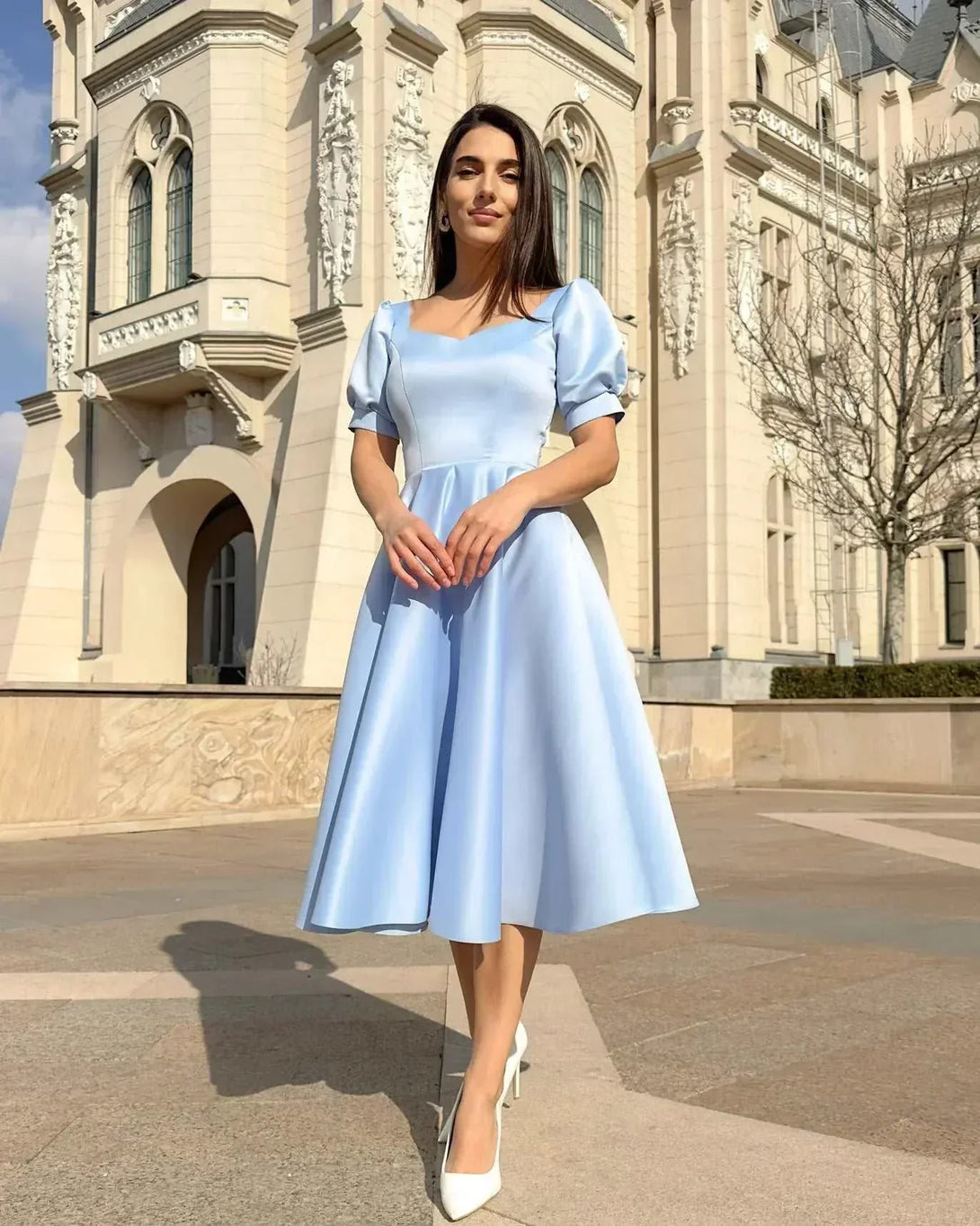 Rochie eleganta de ocazie albastra cu croială A-line, design rafinat, fundal arhitectural.