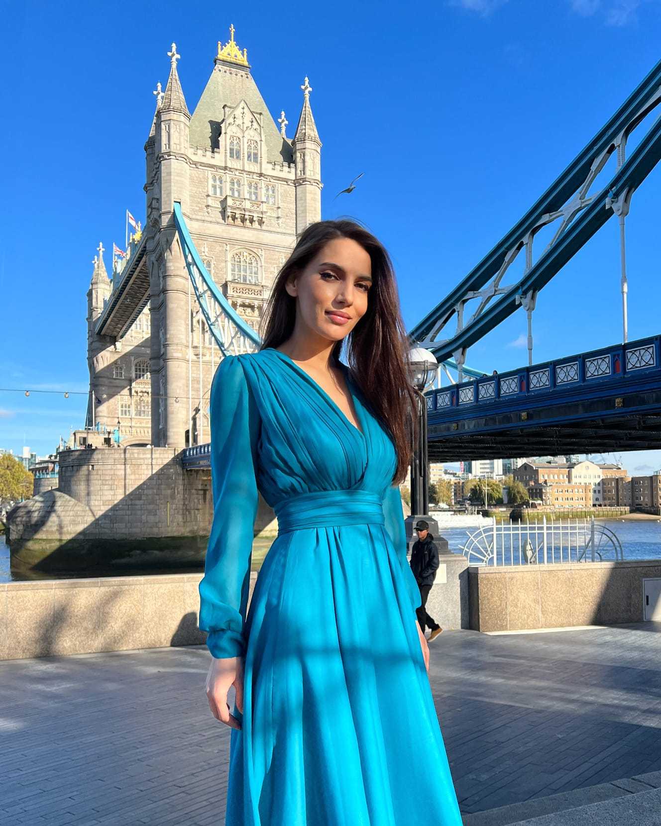 Rochie de ocazie lungă din voal verde smarald cu decolteu în V și mâneci lungi, potrivită pentru evenimente elegante.