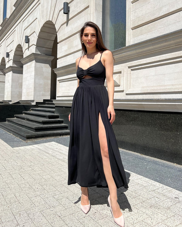 Rochie neagra cu slit pe picior și bretele elegante.