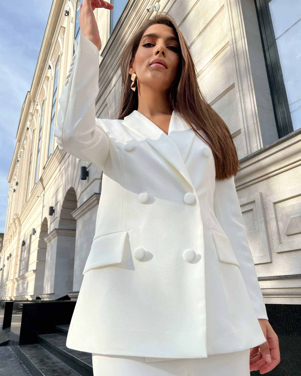 Sacou alb elegant cu două rânduri de nasturi, stil cambrat și guler în V.