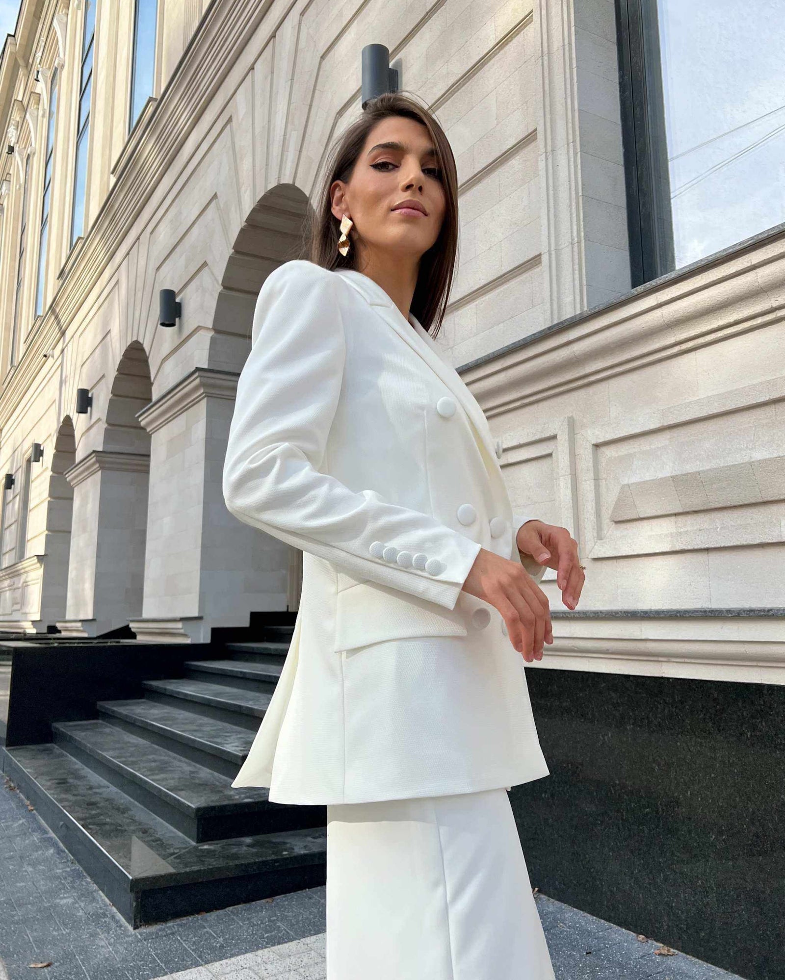 Sacou alb de costum elegant cu două rânduri de nasturi, design cambrat și guler în V.