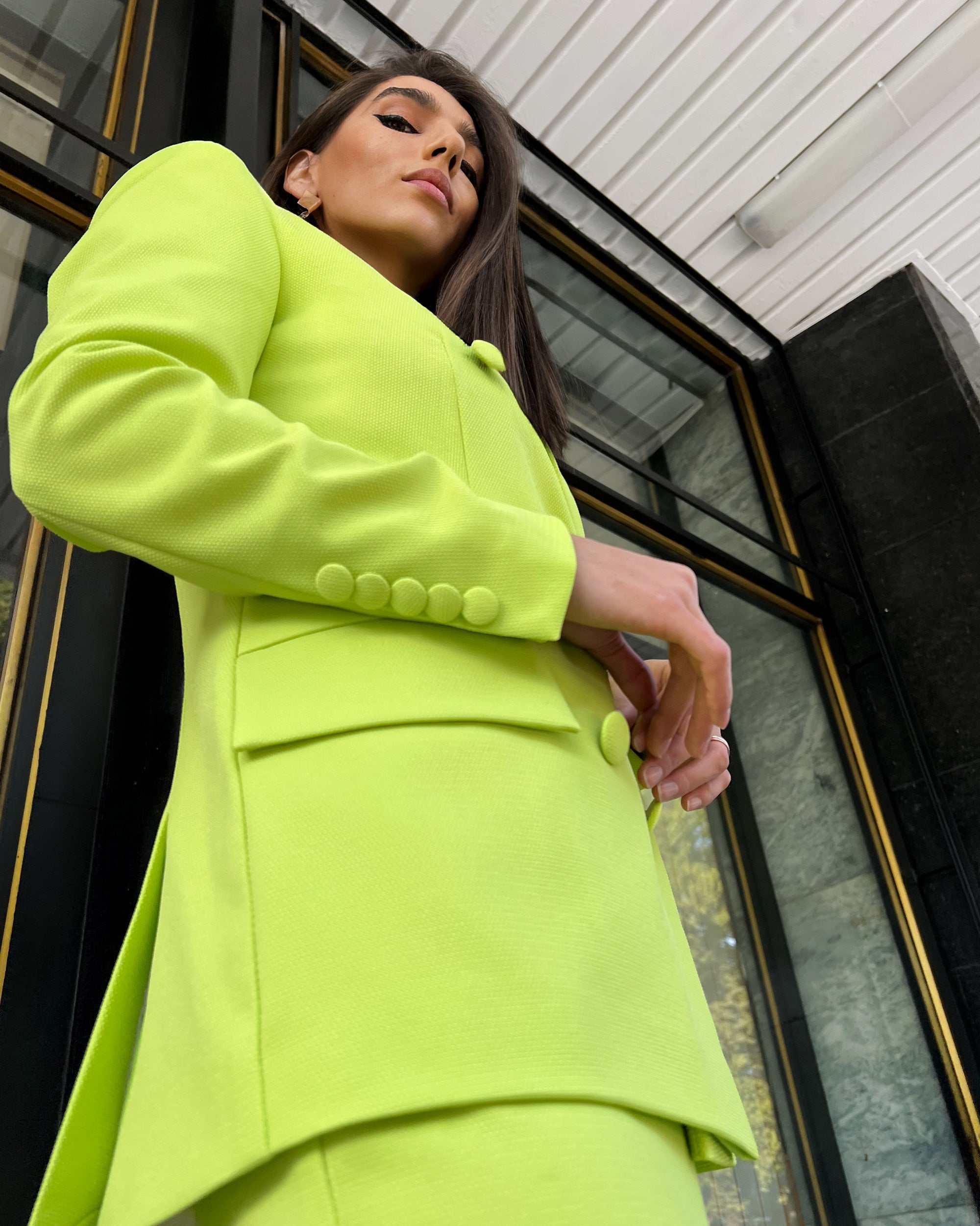 Sacou dama elegant cu două rânduri de nasturi verde lime, model lung și cambrat, cu șliț dublu și căptușeală interioară.