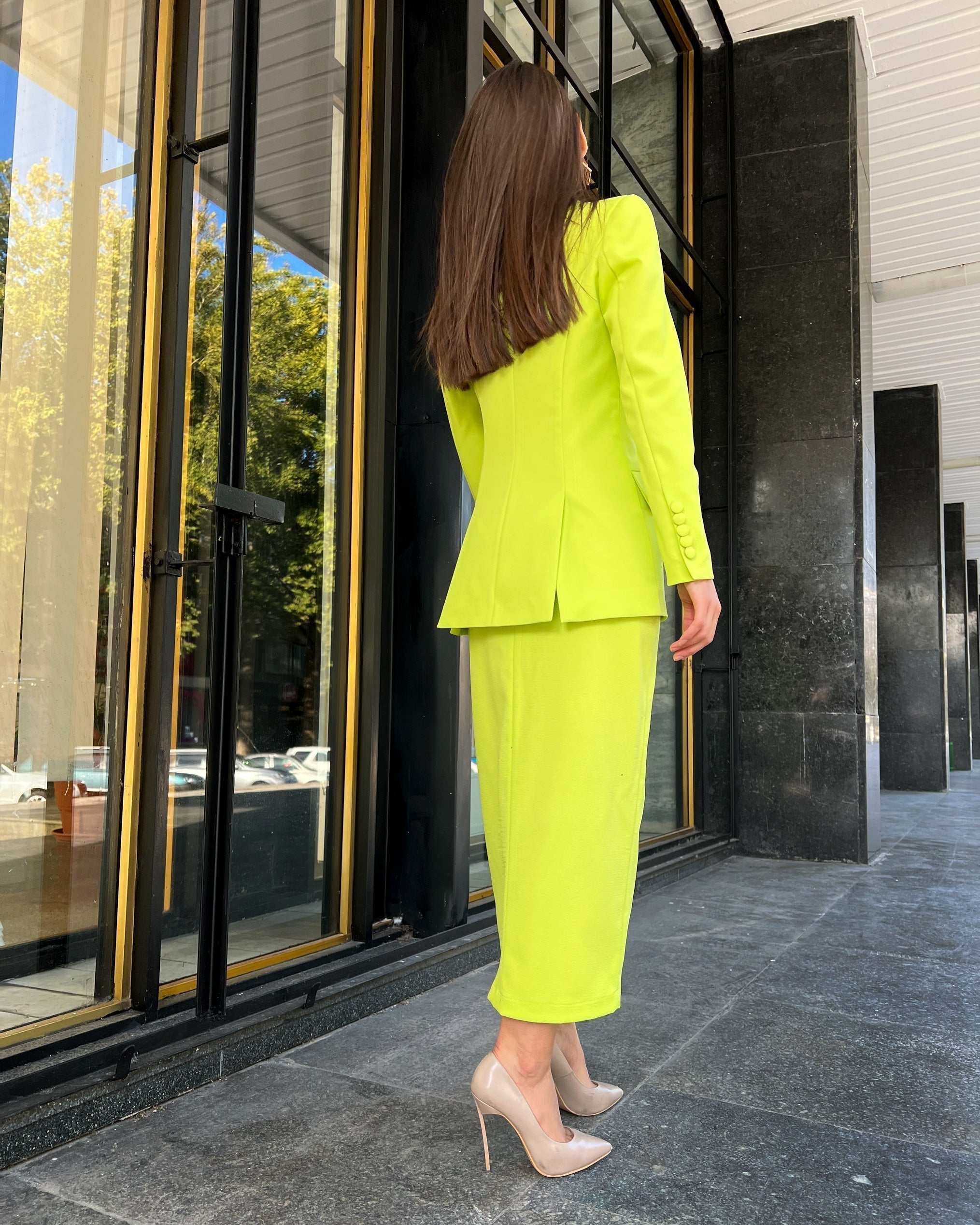 Sacou dama elegant cu două rânduri de nasturi, model cambrat și lung, în culori vibrante, purtat pe stradă.