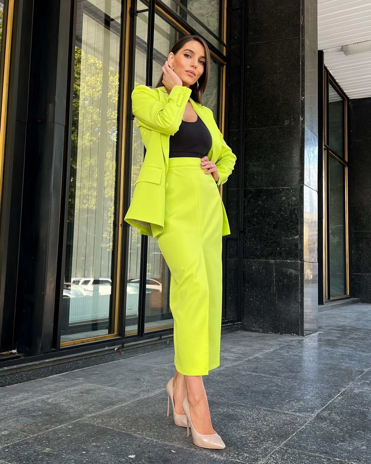 Sacou dama elegant cu două rânduri de nasturi, model cambrat și guler în V, purtat de o femeie în picioare.