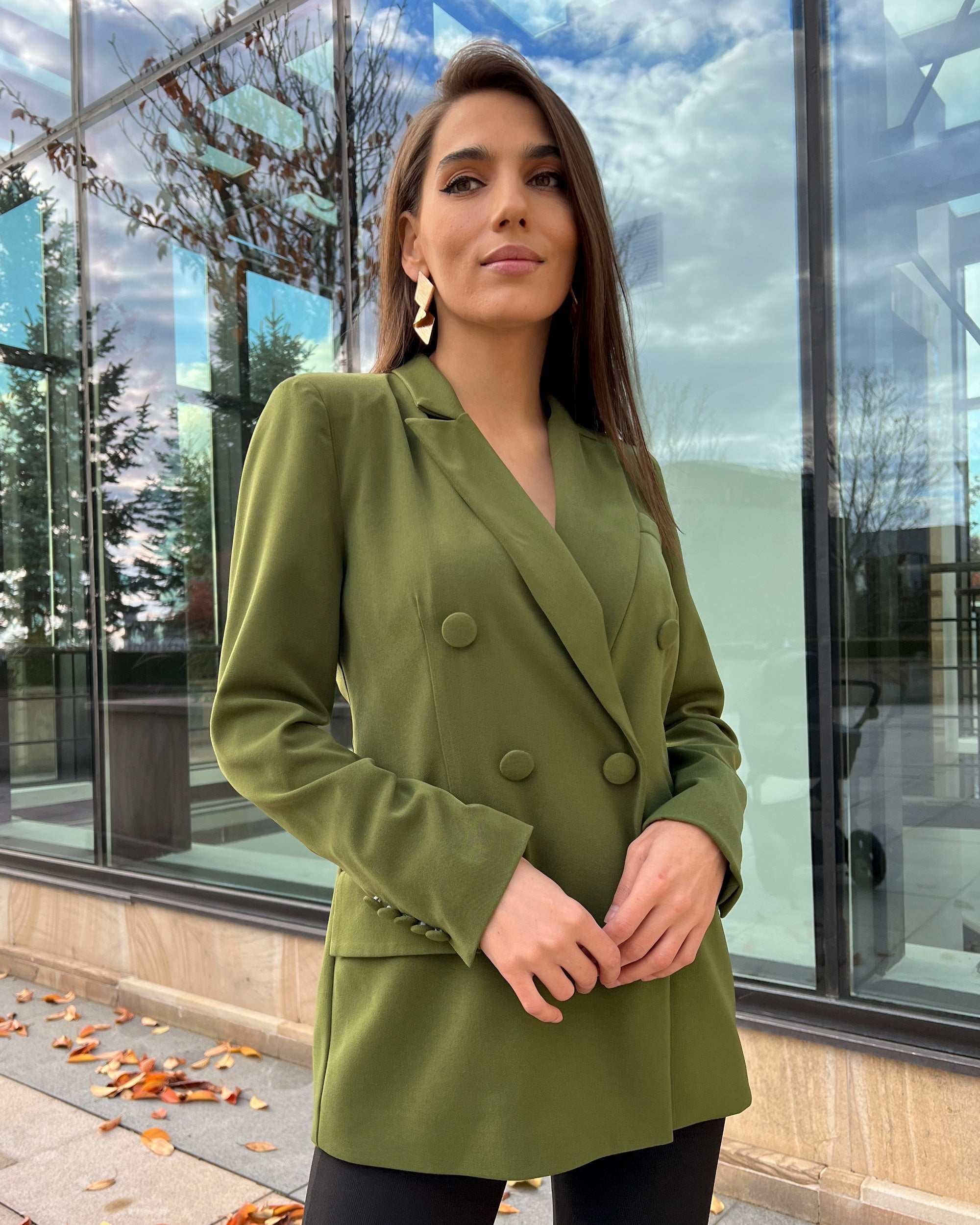 Sacou dama verde cu două rânduri de nasturi, guler în V, mâneci lungi și buzunare decorative.