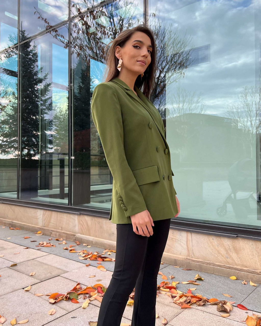 Sacou dama verde cu două rânduri de nasturi și model cambrat, purtat de o persoană afară.