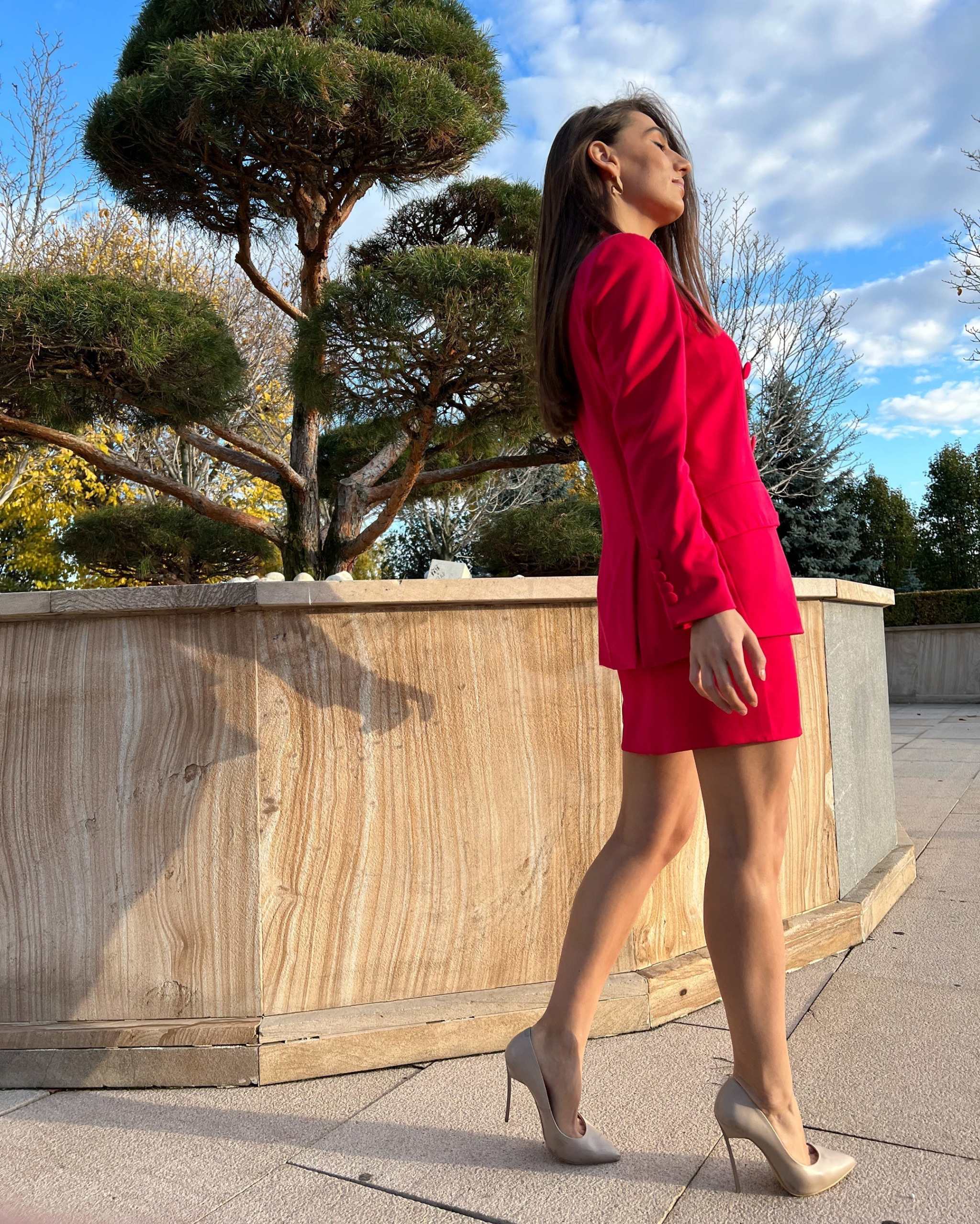 Sacou dama fucsia cu două rânduri de nasturi, model cambrat și lung, purtat de femeie afară.